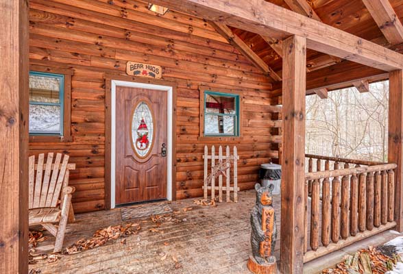 Wooden front porch with the cabin sign above the door
