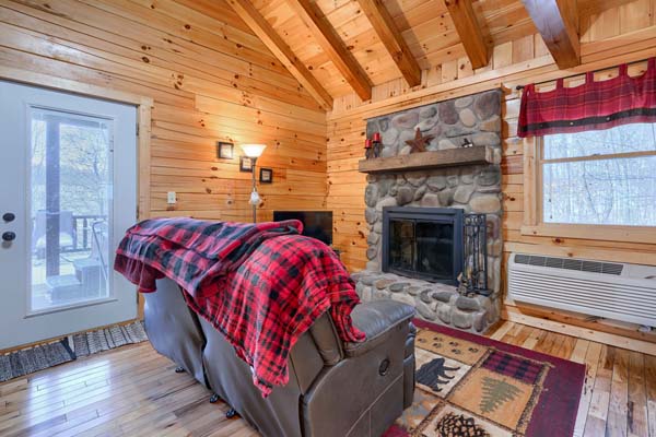 Sofa facing the stone fireplace next to the patio doors