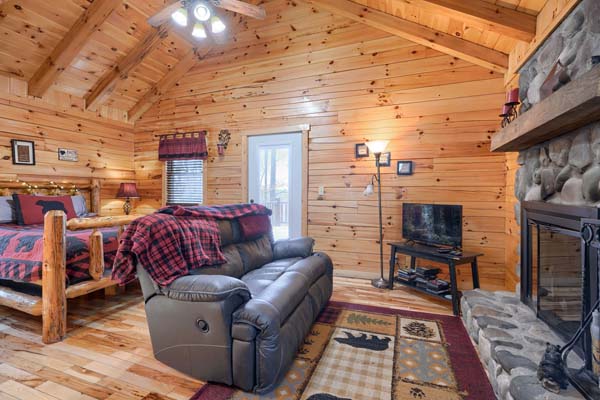 Living area with sofa, fireplace and the log bed beyond