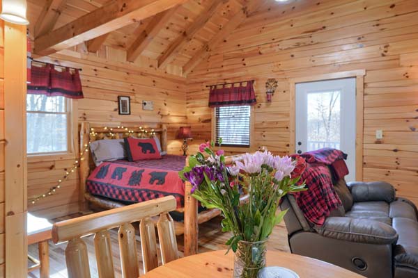 Side table with flowers and the log bed behind