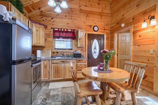 Wooden dining table for two with the entry door behind