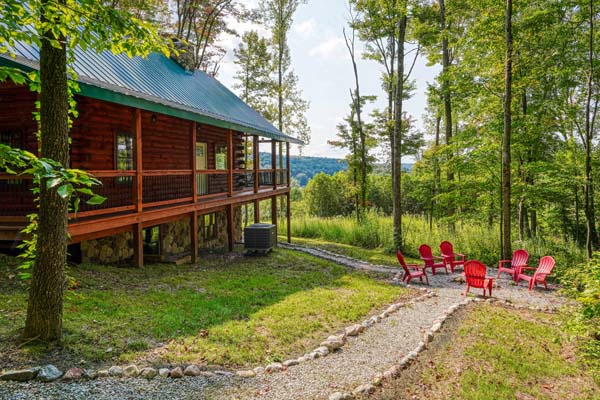 Front of the cabin with porch and red chairs