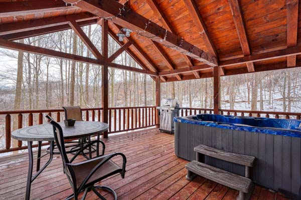 Large covered deck with hot tub and patio furniture