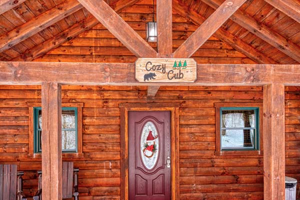 Cabin entrance with the Cozy Cub sign above the door