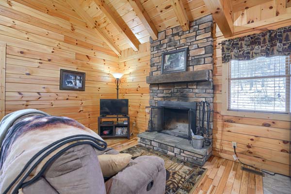 Sofa facing the stone fireplace and window
