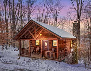 Bear Hugs Cabin with stone chimney in the winter woods