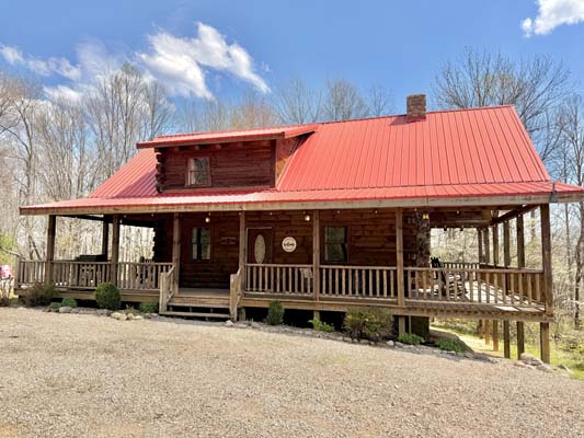 Lonestar Cabin, a two story log cabin on a wooded ridge