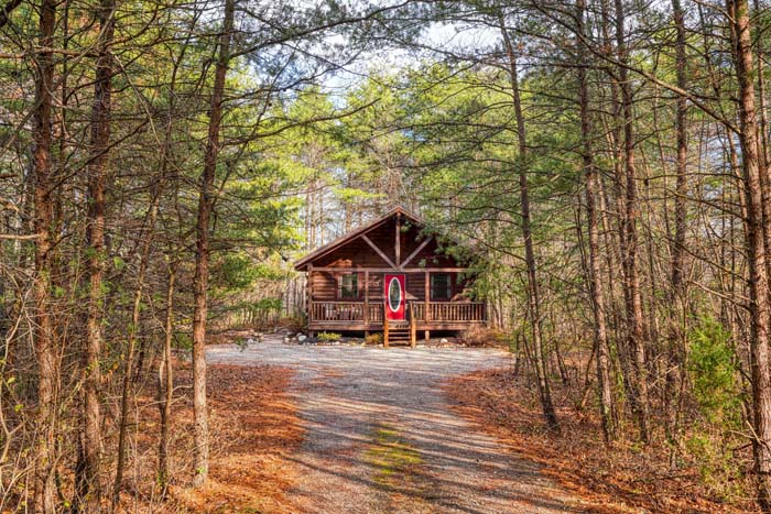 Log cabin exterior at the end of a gravel drive